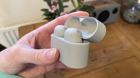 Sony WF-1000XM6 earbuds next to the older-gen. WF-1000XM5 and WF-C710N, on colorful table